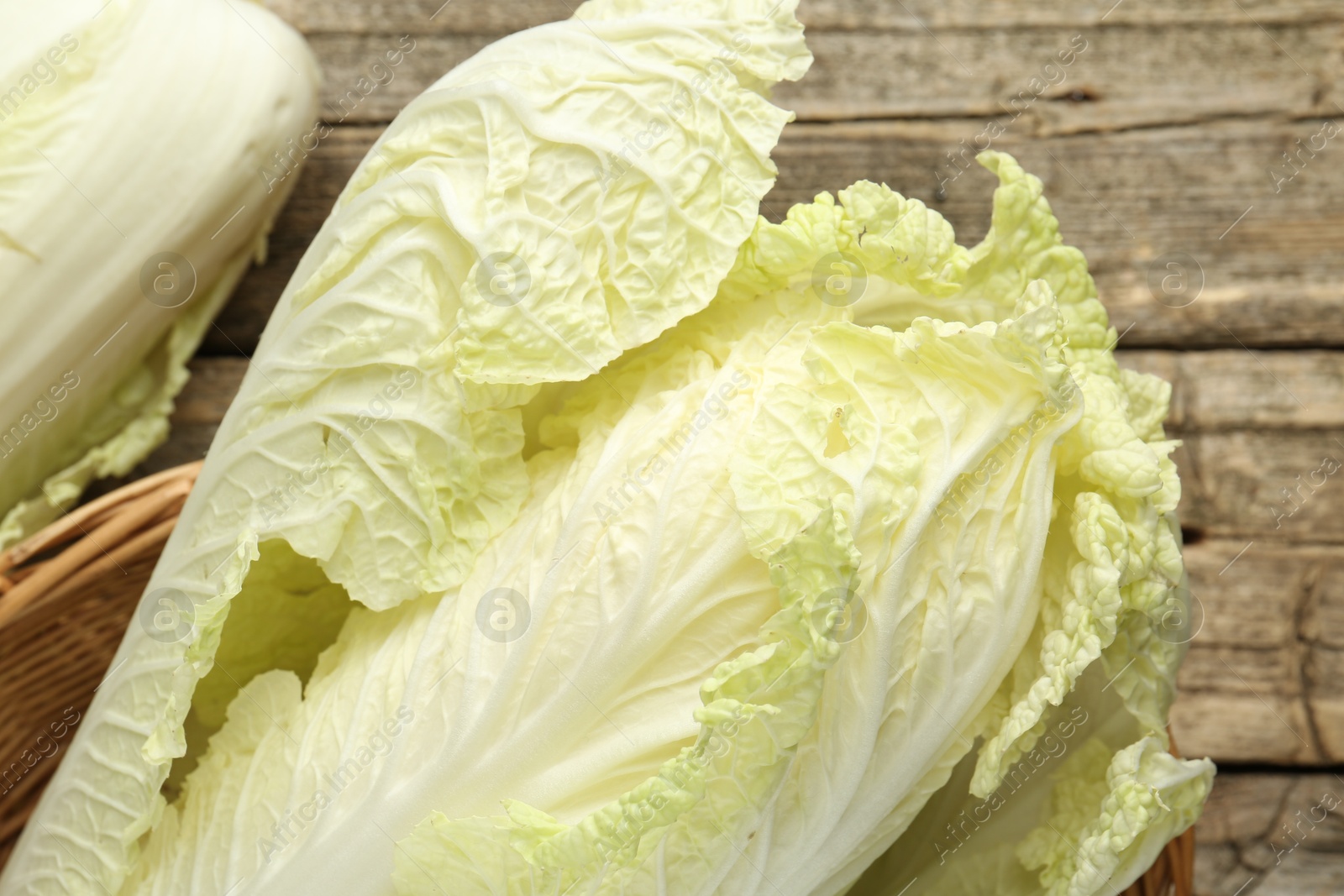 Fresh Chinese cabbages in wicker basket on wooden table, top view Photo of Fresh Chinese cabbages in wicker basket on wooden table, top view