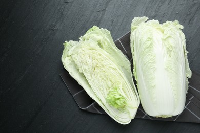 Photo of Chinese cabbages on black table, top view. Space for text