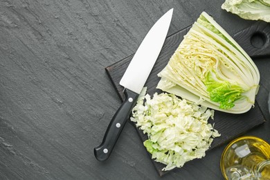 Photo of Cut Chinese cabbage and knife on black table, flat lay. Space for text