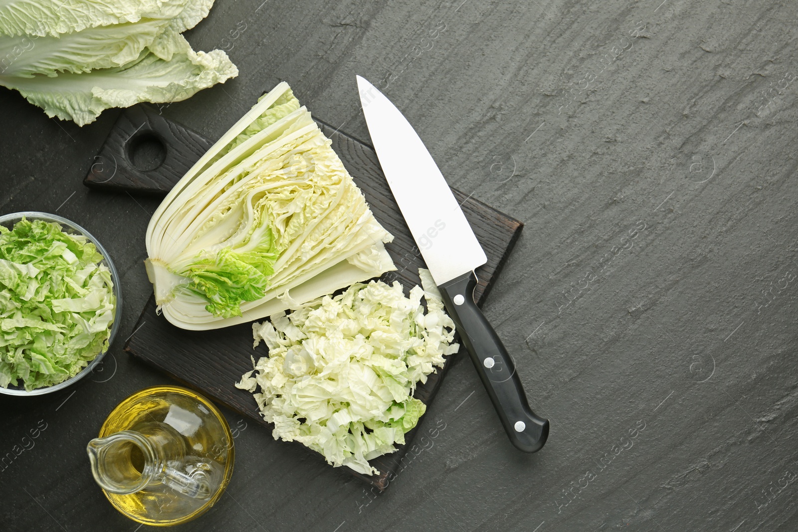 Cut Chinese cabbage and knife on black table, flat lay. Space for text Photo of Cut Chinese cabbage and knife on black table, flat lay. Space for text