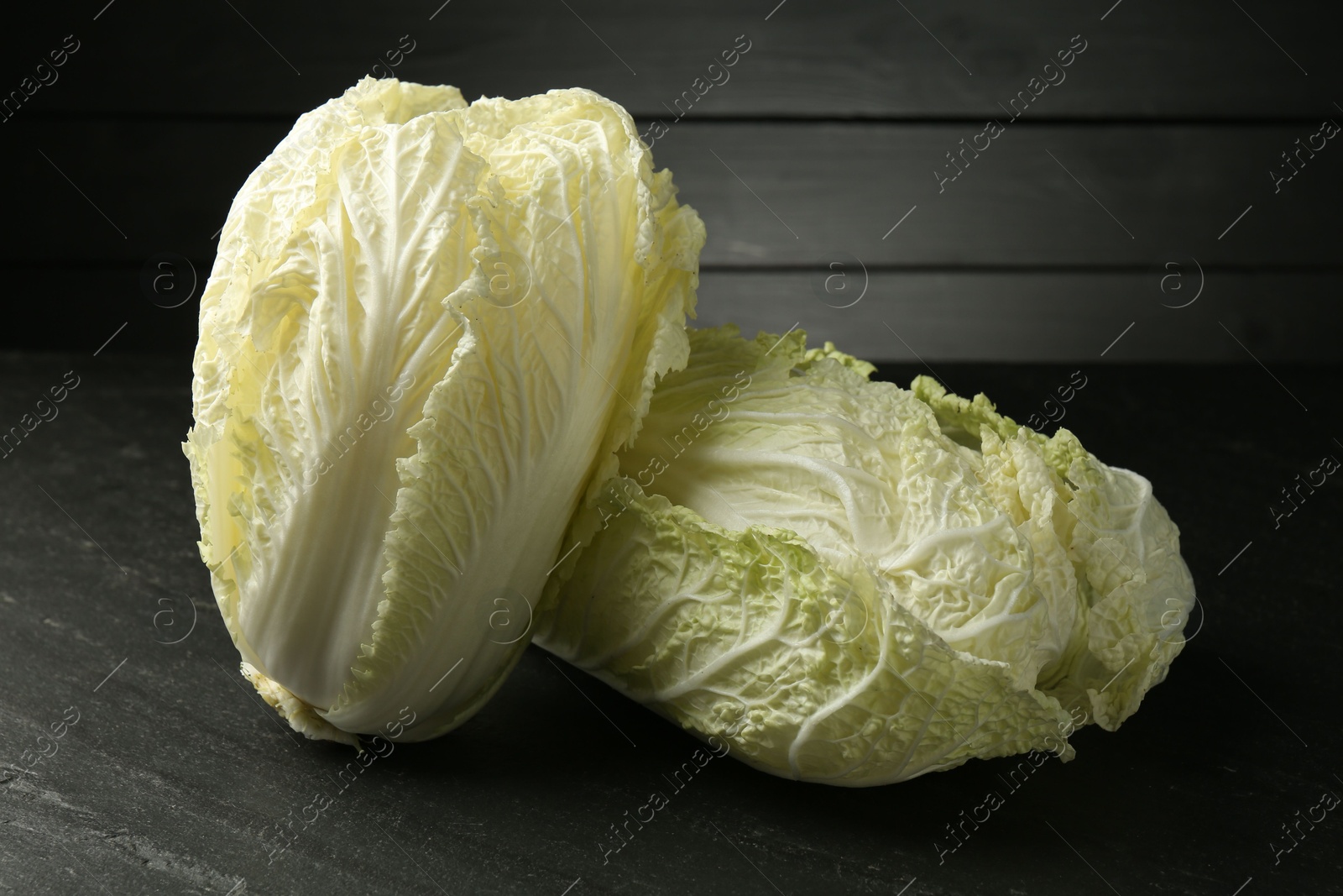 Fresh Chinese cabbages on black table, closeup Photo of Fresh Chinese cabbages on black table, closeup