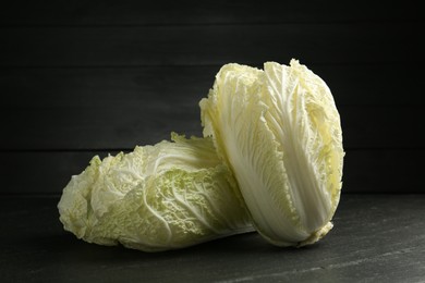 Photo of Fresh Chinese cabbages on black table, closeup
