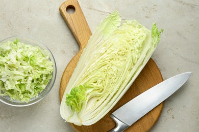 Photo of Cut Chinese cabbage and knife on light grey table, top view
