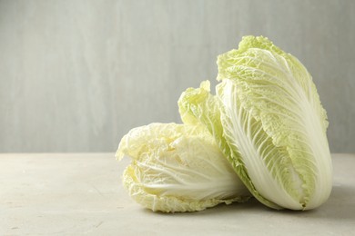 Photo of Fresh Chinese cabbages on light grey table, closeup. Space for text
