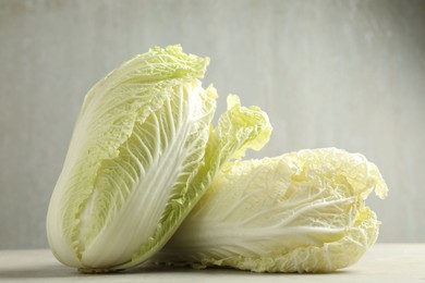 Photo of Fresh Chinese cabbages on light grey table, closeup