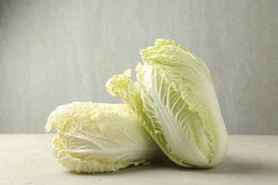 Photo of Fresh Chinese cabbages on light grey table, closeup