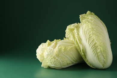 Photo of Fresh Chinese cabbages on green background, closeup. Space for text