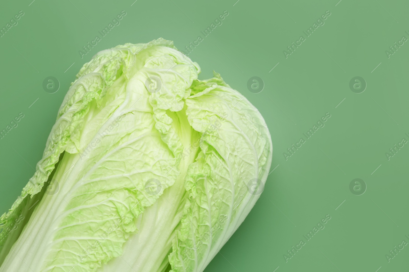 Fresh Chinese cabbage on green background, top view. Space for text Photo of Fresh Chinese cabbage on green background, top view. Space for text