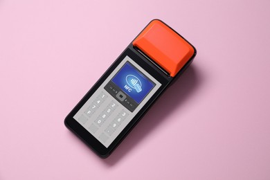 Image of Payment terminal with NFC system on pink background, top view