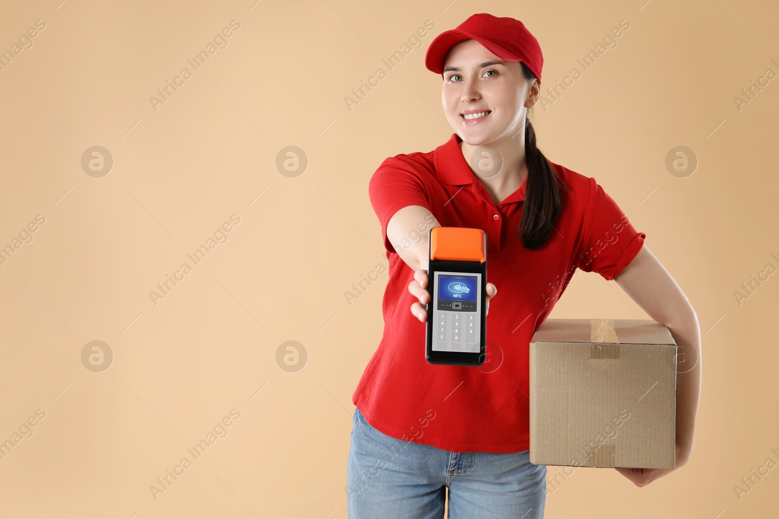 Worker holding payment terminal with NFC system and cardboard box on pale brown background. Space for text Image of Worker holding payment terminal with NFC system and cardboard box on pale brown background. Space for text