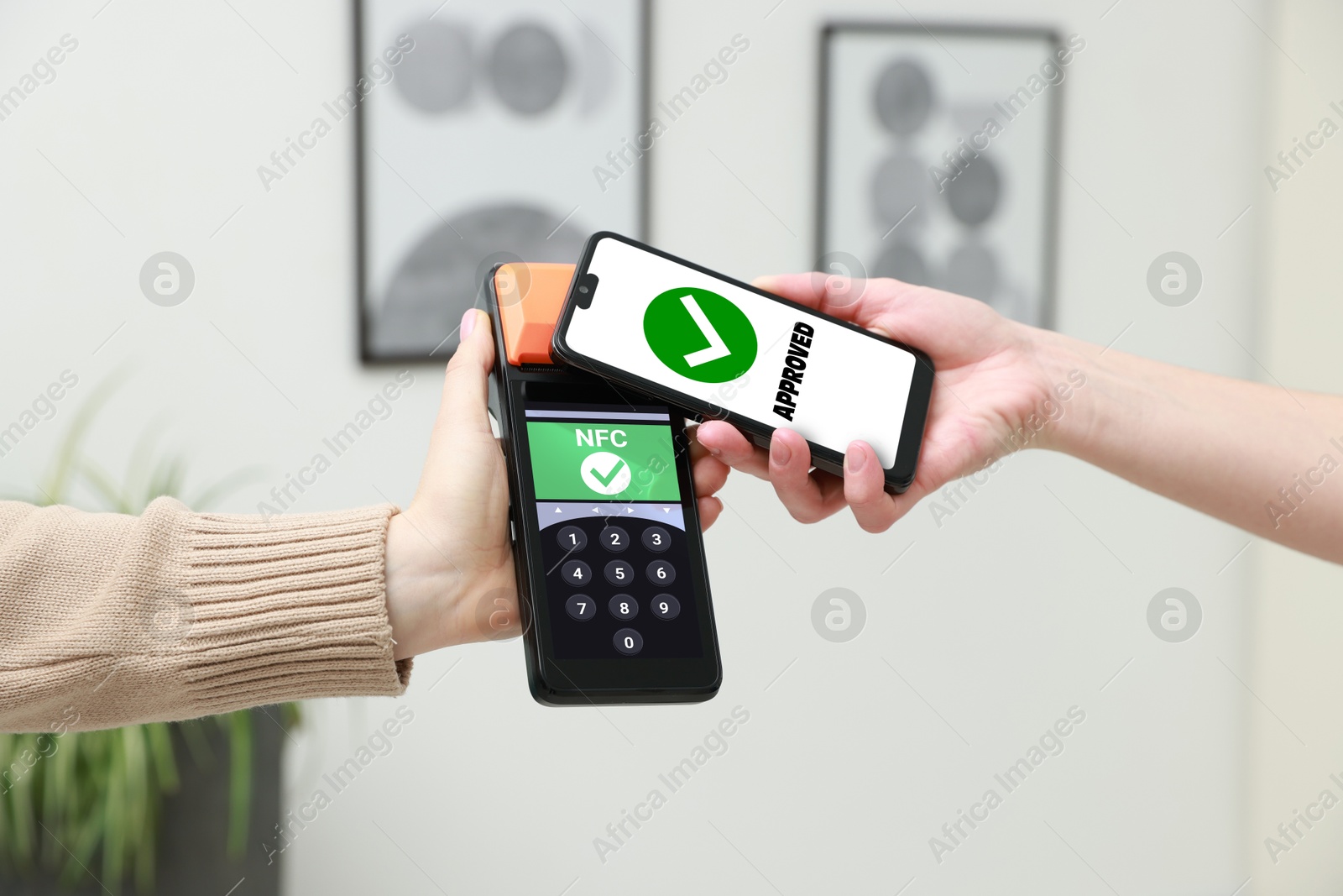 Payment terminal with NFC system. Client using mobile phone to pay for service indoors, closeup Image of Payment terminal with NFC system. Client using mobile phone to pay for service indoors, closeup