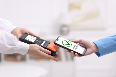 Image of Payment terminal with NFC system. Client using mobile phone to pay for service indoors, closeup