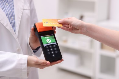 Image of Payment terminal with NFC system. Client using credit card to pay for service in hospital, closeup