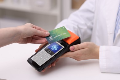 Image of Payment terminal with NFC system. Client using credit card to pay for service in hospital, closeup