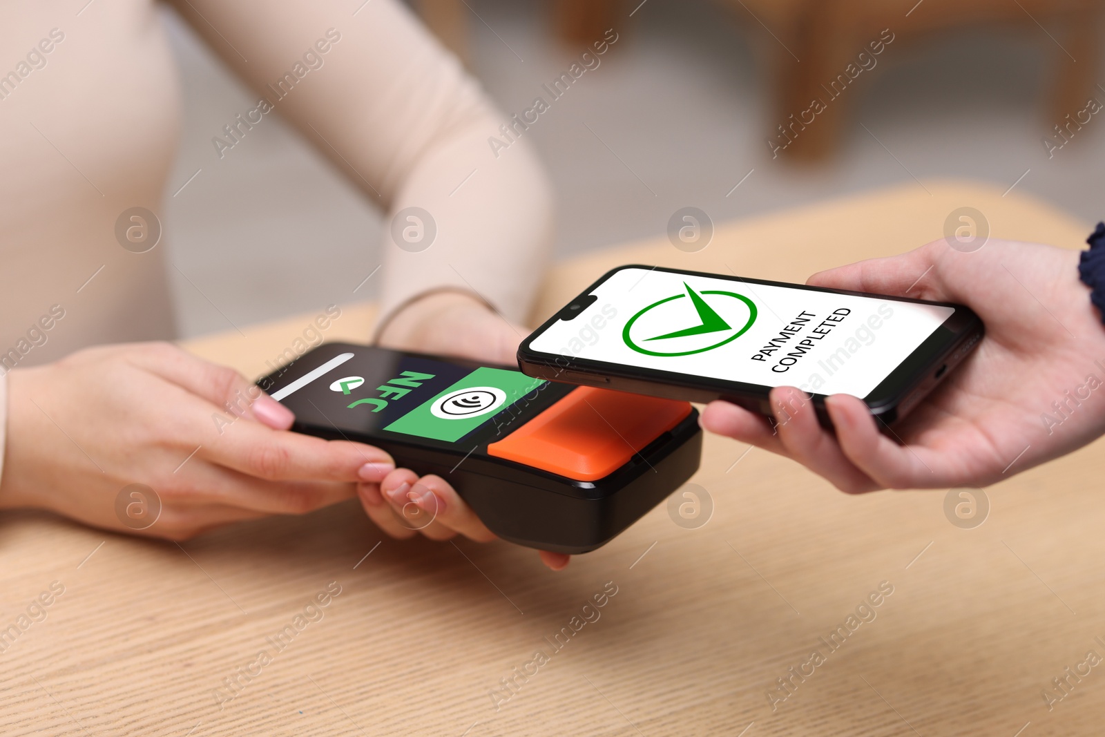 Payment terminal with NFC system. Client using mobile phone to pay for service indoors, closeup Image of Payment terminal with NFC system. Client using mobile phone to pay for service indoors, closeup