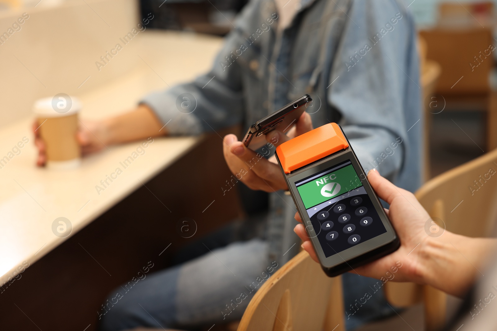 Payment terminal with NFC system. Client using credit card to pay for service in cafe, closeup Image of Payment terminal with NFC system. Client using credit card to pay for service in cafe, closeup