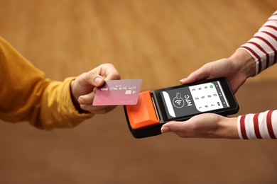 Image of Payment terminal with NFC system. Client using credit card to pay for service indoors, closeup