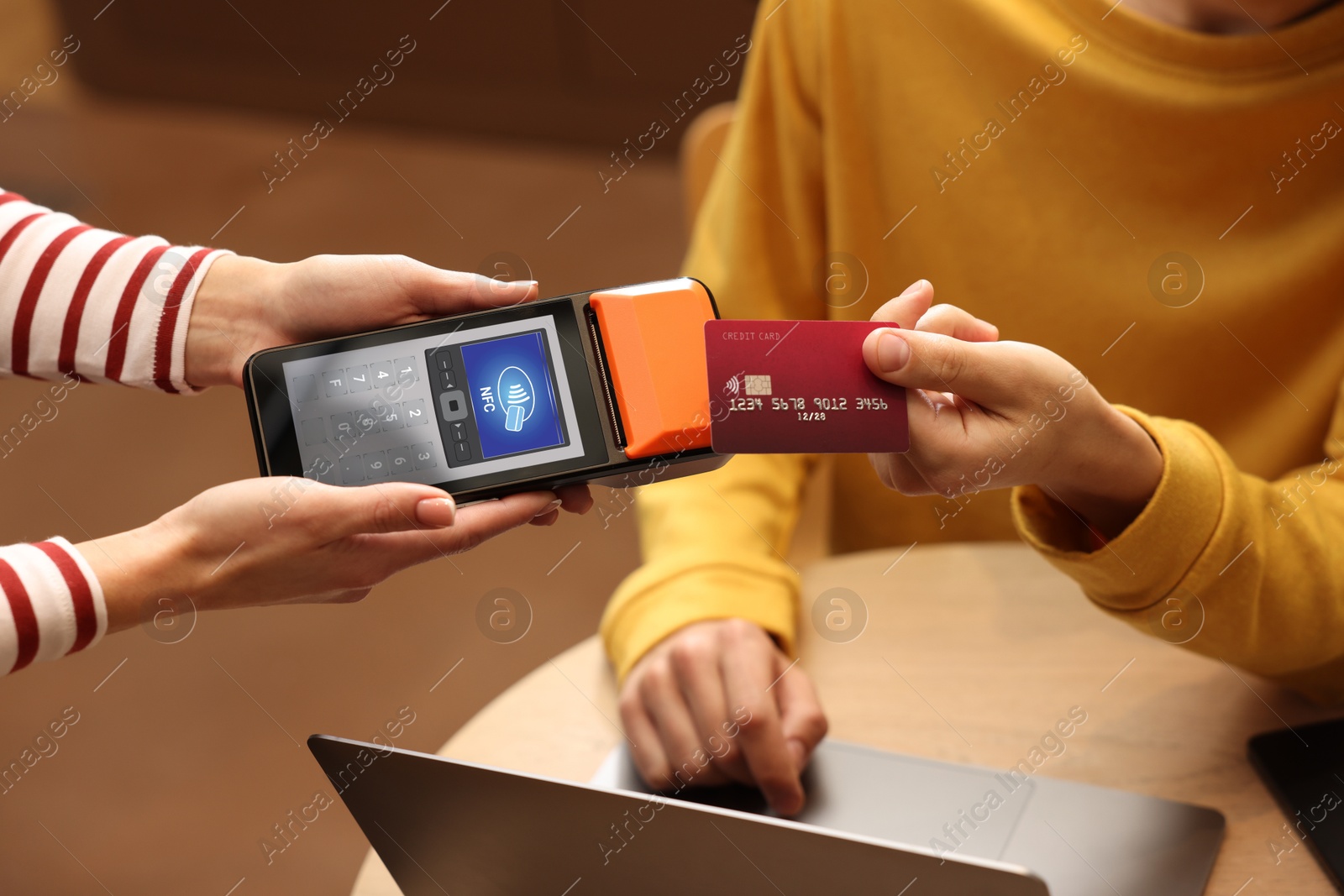 Payment terminal with NFC system. Client using credit card to pay for service indoors, closeup Image of Payment terminal with NFC system. Client using credit card to pay for service indoors, closeup