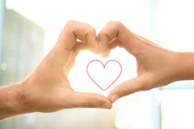 Image of Man and woman making heart with their hands indoors, closeup
