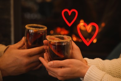 Image of Couple with tasty mulled wine indoors, closeup. Drawn hearts near them