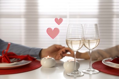 Image of Couple holding hands during romantic dinner at home, closeup. Drawn hearts near them