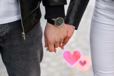 Image of Lovely couple holding hands outdoors, closeup. Drawn hearts near them