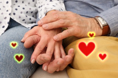 Image of Lovely mature couple holding hands, closeup. Drawn hearts near them