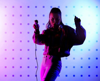 Image of Beautiful woman with disco ball earrings singing on stage