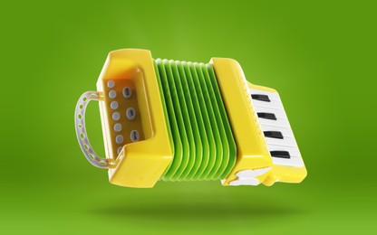 Image of Toy accordion in air on green background. Child's musical instrument