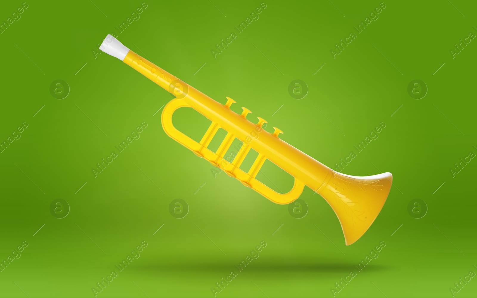 Yellow toy horn in air on green background. Child's musical instrument Image of Yellow toy horn in air on green background. Child's musical instrument