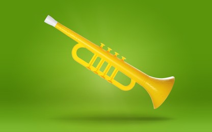 Image of Yellow toy horn in air on green background. Child's musical instrument