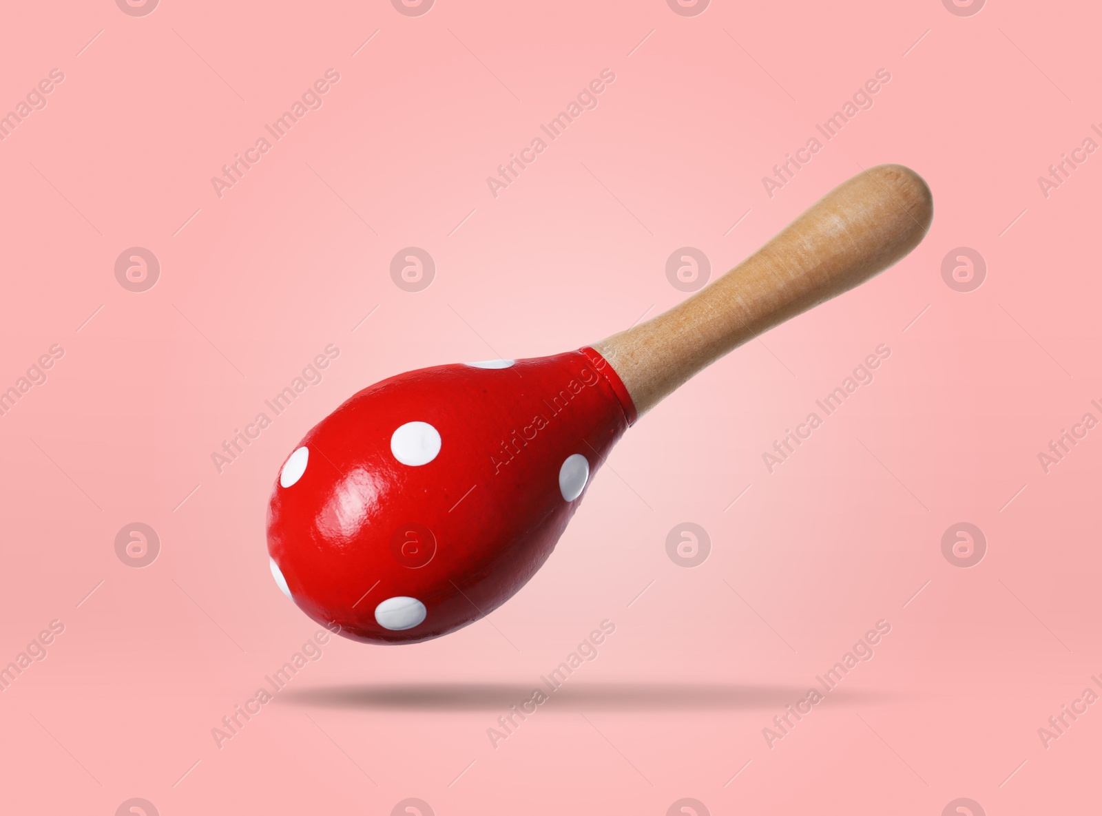Toy maraca in air on pink background. Child's musical instrument Image of Toy maraca in air on pink background. Child's musical instrument