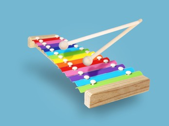 Image of Toy xylophone in air on light blue background. Child's musical instrument
