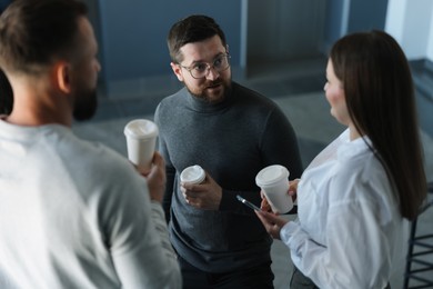 Photo of Colleagues with coffee on stairs in office during break