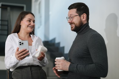 Photo of Colleagues with coffee on stairs in office during break