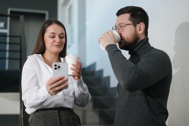 Photo of Colleagues with coffee on stairs in office during break