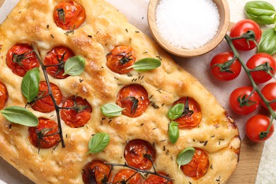 Photo of Delicious focaccia with tomatoes and spices on table, flat lay