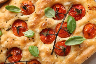 Photo of Delicious focaccia with tomatoes and spices as background, top view