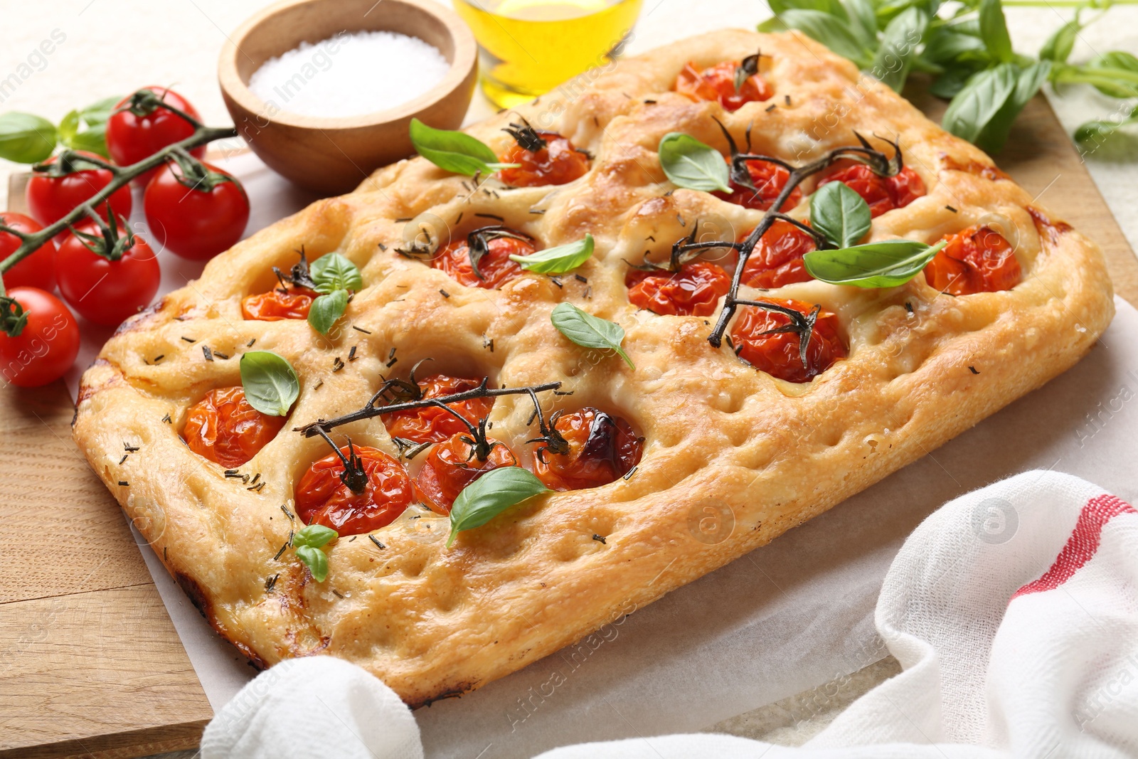 Delicious focaccia with tomatoes, spices and oil on table, closeup Photo of Delicious focaccia with tomatoes, spices and oil on table, closeup