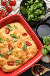 Photo of Delicious focaccia with tomatoes, spices and oil on table, flat lay