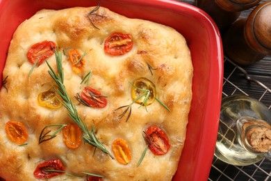 Photo of Delicious focaccia with tomatoes, spices and oil on table, flat lay