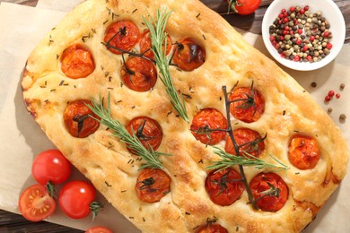 Photo of Delicious focaccia with tomatoes and spices on table, flat lay