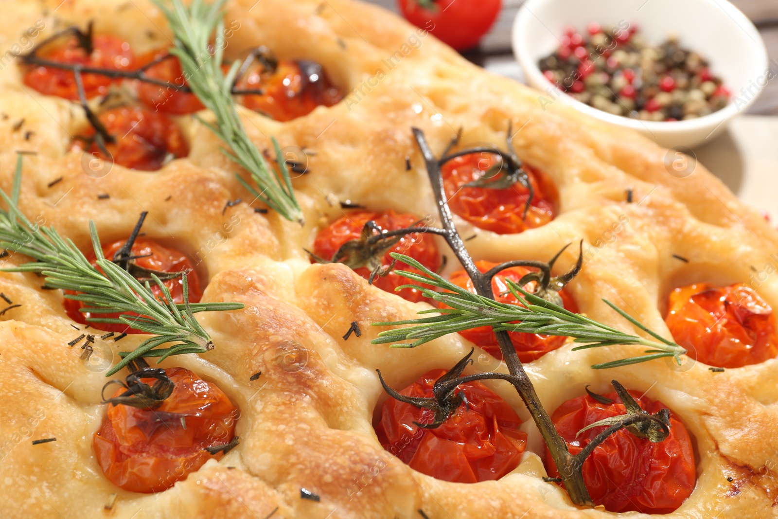 Delicious focaccia with tomatoes and spices on table, closeup Photo of Delicious focaccia with tomatoes and spices on table, closeup