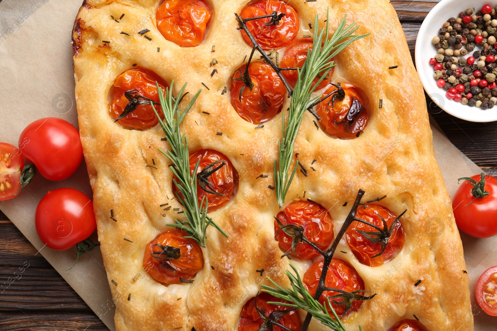 Delicious focaccia with tomatoes and spices on table, flat lay Photo of Delicious focaccia with tomatoes and spices on table, flat lay