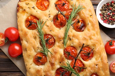 Photo of Delicious focaccia with tomatoes and spices on table, flat lay