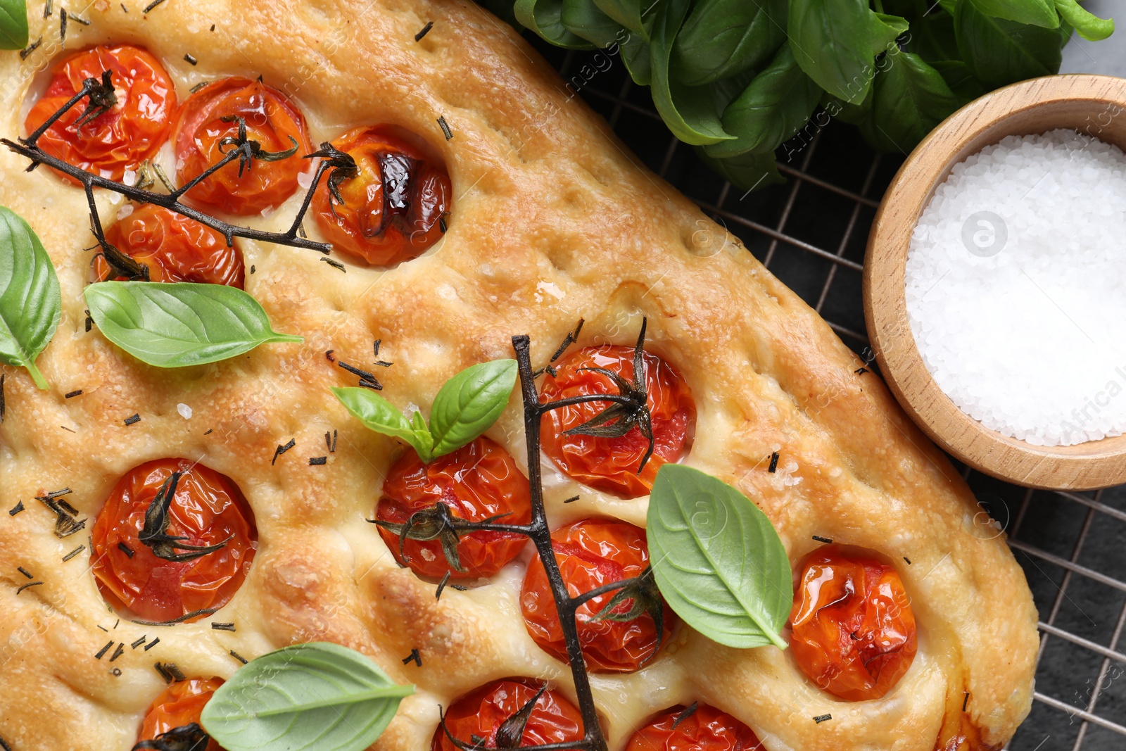 Delicious focaccia with tomatoes and spices on table, flat lay Photo of Delicious focaccia with tomatoes and spices on table, flat lay