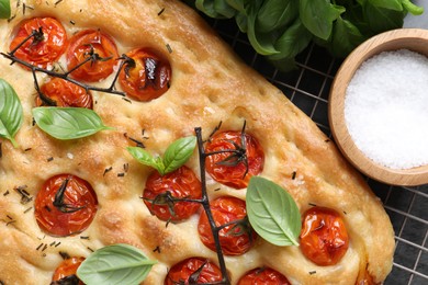 Photo of Delicious focaccia with tomatoes and spices on table, flat lay