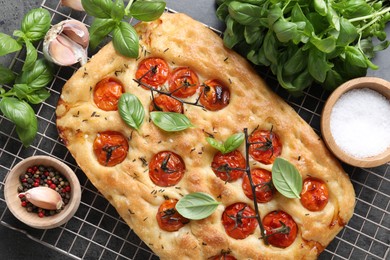 Photo of Delicious focaccia with tomatoes and spices on table, flat lay