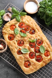 Photo of Delicious focaccia with tomatoes and spices on gray table, flat lay