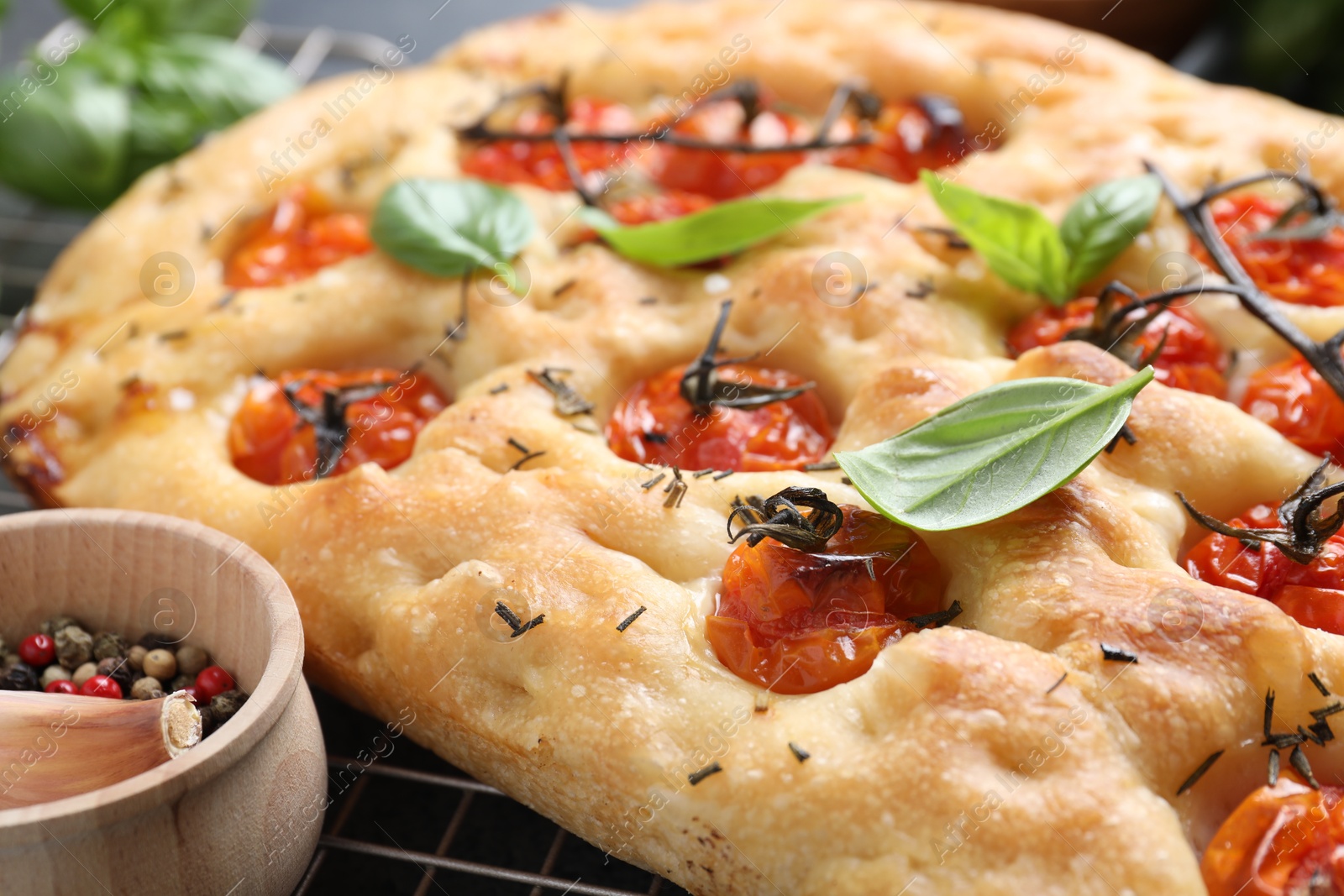 Delicious focaccia with tomatoes and spices on table, closeup Photo of Delicious focaccia with tomatoes and spices on table, closeup